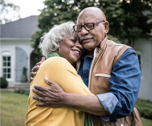 A woman hugs her spouse after he returns home from receiving high-quality stroke care.